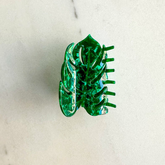 Monstera claw clip flat on a white marble surface